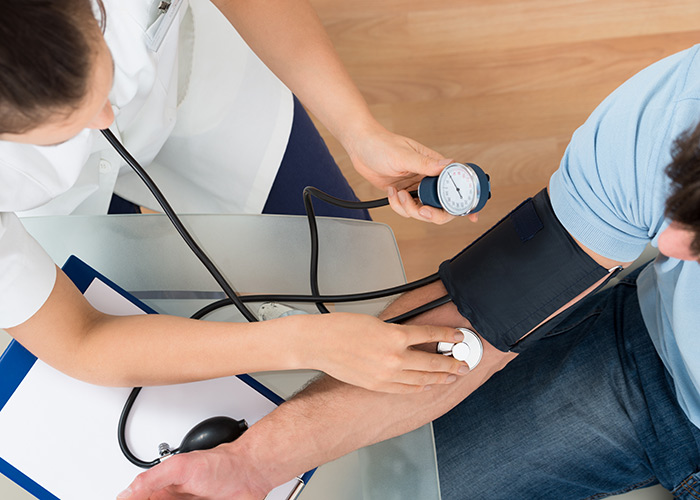 Overhead view of medical assistant taking a man's blood pressure