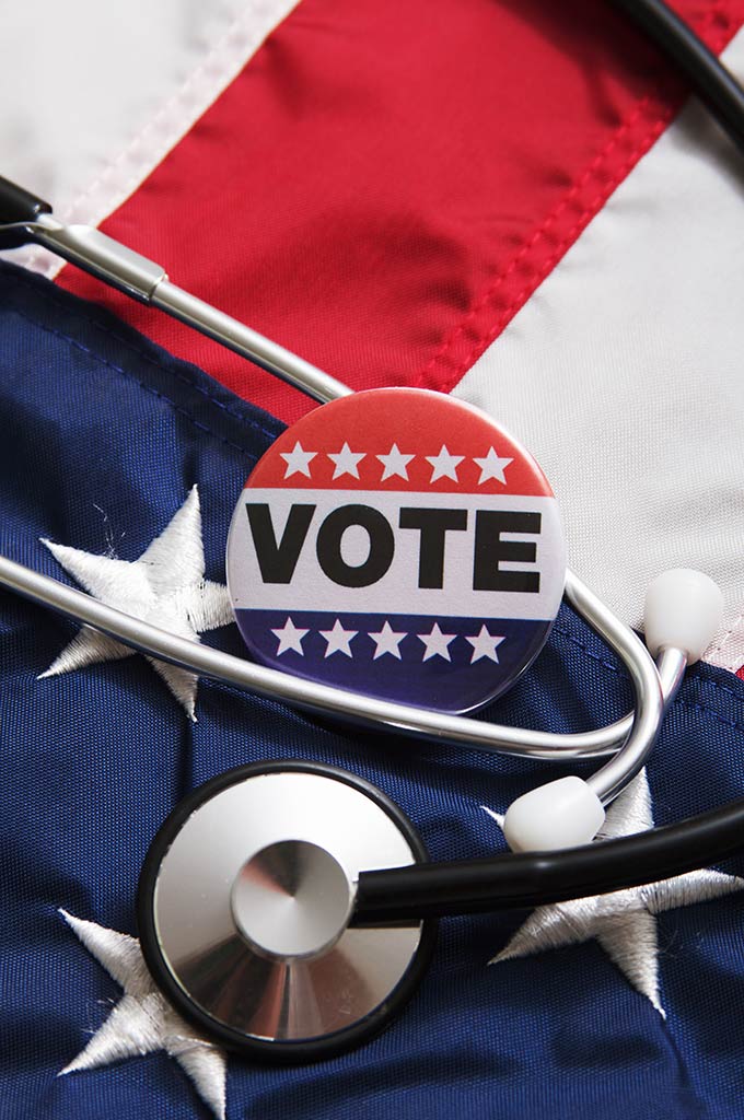 "Vote" button and stethoscope on top of US flag